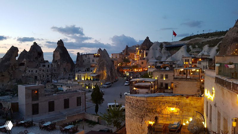 Ночная панорама Гёреме: пещерные отели с подсветкой, террасы и фрагменты скал, создающие уютную туристическую атмосферу в центре поселка.