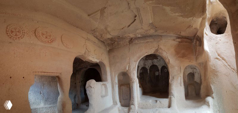 Интерьер пещерной церкви в Зельве: арочные ниши, остатки красных росписей и каменные скамьи, создающие атмосферу древнего монастыря.