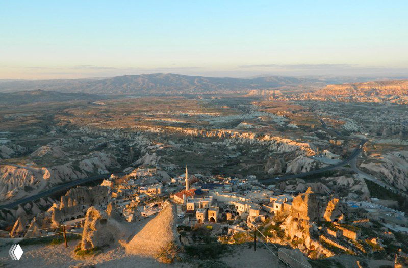 Панорамный вид с вершины Учхисара на окружающие долины Каппадокии, поселения и характерные туфовые формы под мягким светом.