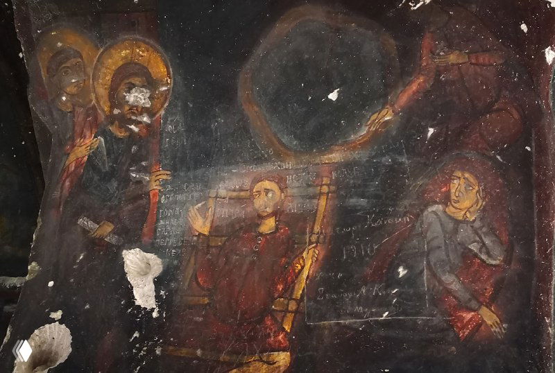 Фрагмент тёмной фрески с изображениями святых и сценой у трона в монастыре Кешлик, часть рисунка покрыта сажей, но композиция остаётся читаемой.