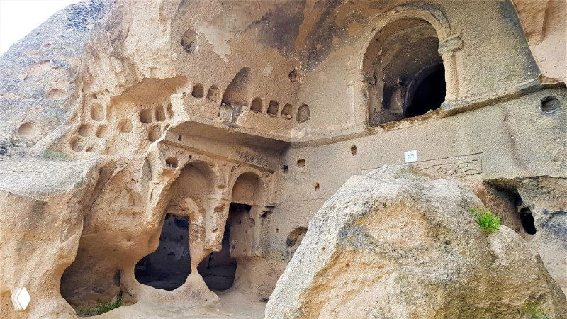 Вырубленные в туфе входы и ниши пещерных помещений монастыря Селиме, видны отверстия и коридоры внутри скалы
