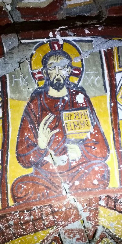 Икона Христа в традиционной манере на фреске внутри каменной церкви Ихлары, видны краски и трещины поверхности