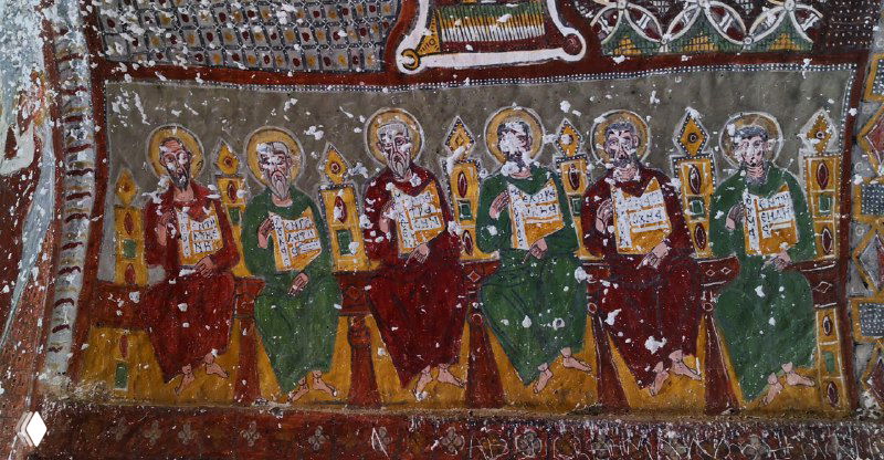 Группа фигур святых, сидящих в ряд и изображённых с манускриптами и орнаментом — часть комплекса росписей Ихлары