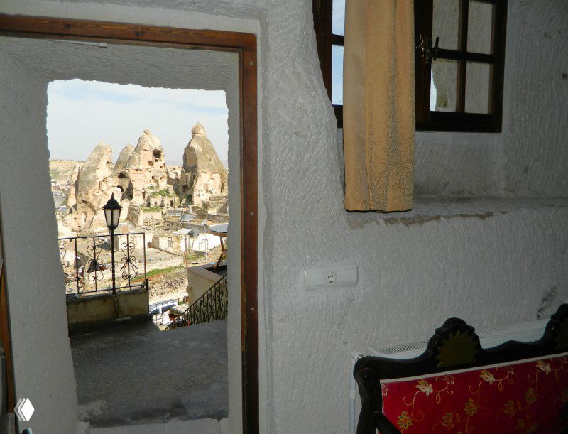 Вид из пещерного окна на туфовые пики и балконы соседних домов в Гёреме, кадр показывает близость номеров к характерному ландшафту.