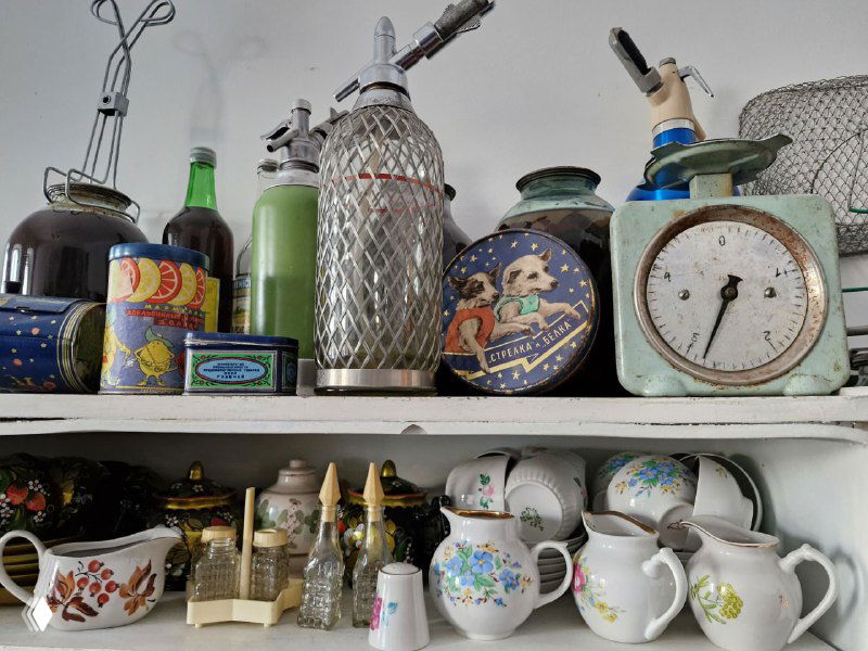 Полка с чашками, старинными бутылочками и кухонными мелочами: коллекция домашней утвари в музейной экспозиции Коломны