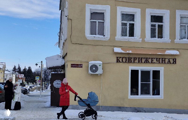 Фасад кафе «Коврижечная» в Зарайске зимой: вывеска пекарни, прохожие и детская коляска на тротуаре у входа в заведение.