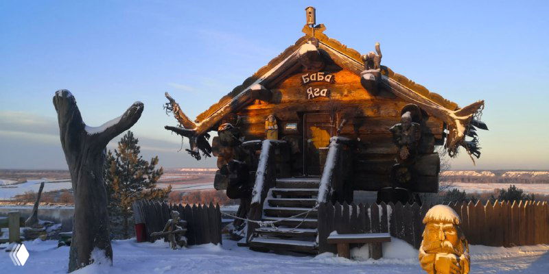 Деревянная изба в русском стиле и украшенная входная часть городка «Абалак» на фоне заснеженного горизонта и утреннего света