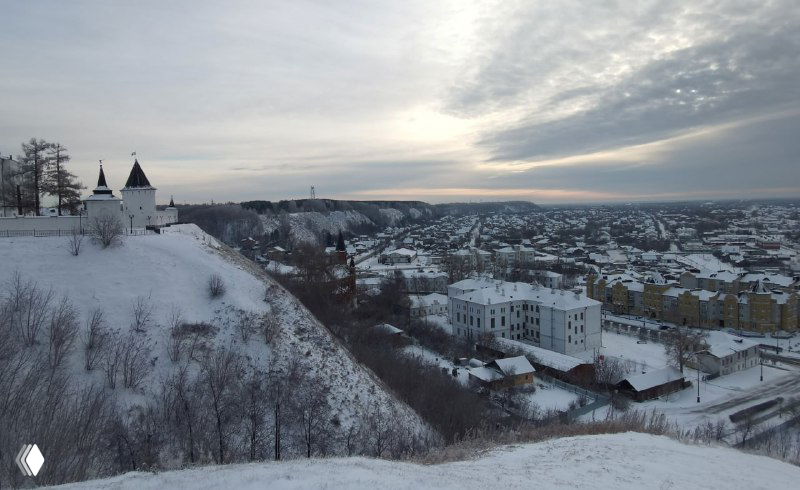 Широкая панорама с вершины Горы на Подгору и городской пейзаж Тобольска: дома, река вдалеке и серое зимнее небо над окраиной.