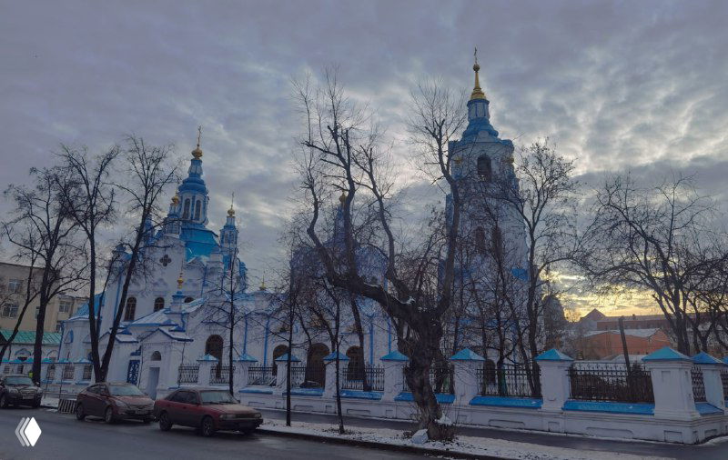 Вечерний вид на Знаменский собор и Спасскую церковь в Тюмени, силуэты куполов на фоне неба ближе к закату, городской пейзаж.
