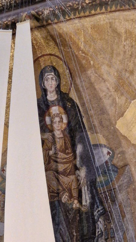 Мозаичное изображение Богоматери в закутке галереи Святой Софии, частично закрытая панелью, прослеживаются следы реставраций и возрастной патина.