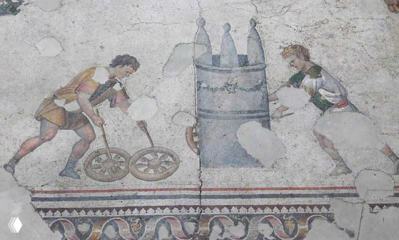 Мозаика с двумя фигурами, катающими обручи или колесики рядом со декоративной архитектурной деталью — бытовая сцена из коллекции музея Араста в Стамбуле.