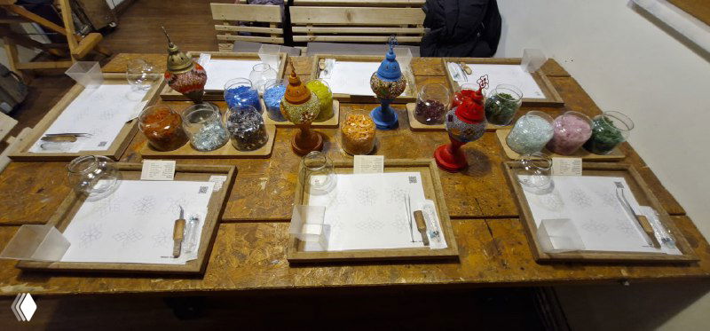 Подготовленные рабочие места мастер-класса: тарелки с инструментами и заготовками на столах, место для выкладки мозаики и сборки лампы.