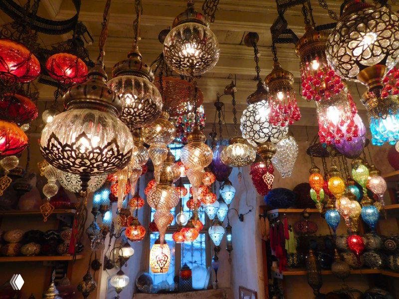 Яркое разноцветное свечение турецких мозаичных ламп в лавке внутри Валиде Хан: множество подвесных светильников разной формы и расцветки.