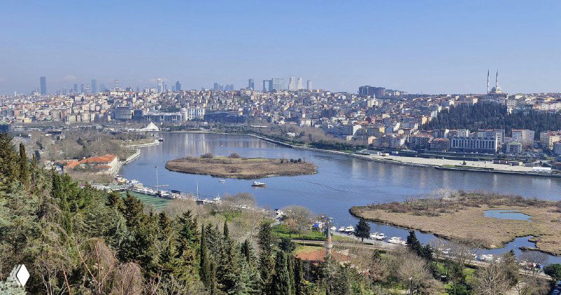 Обширный вид на Золотой Рог с зелёными насаждениями внизу и излучиной воды; панорама подчёркивает геометрию пролива.