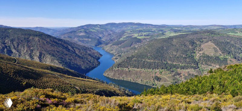 Речной изгиб между отвесными склонами, открывающий панорамный вид с высоты на природные водные артерии вдоль маршрута Камино.