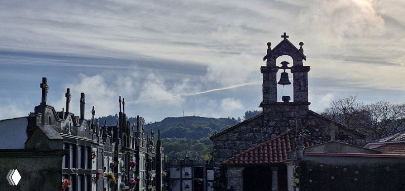 Старинная церковь и кладбищенский ансамбль в одном из населённых пунктов вдоль Камино де Сантьяго, тёмные силуэты на фоне неба.