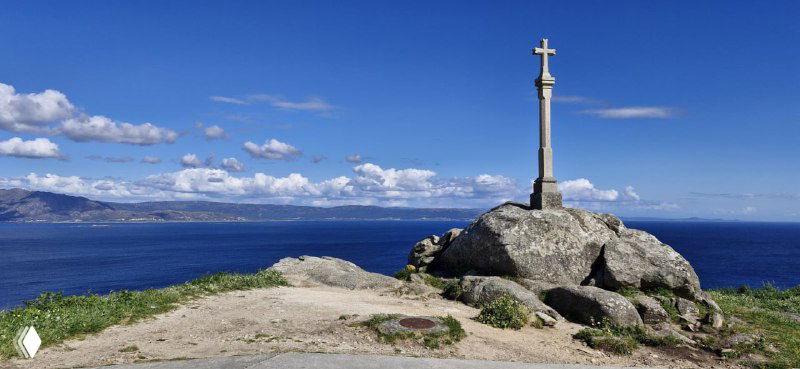 Крест на вершине утёса с видом на бескрайний океан — характерная сцена на Камино, символ паломничества и завершения пути.