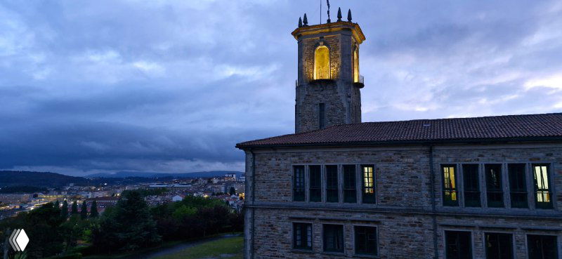 Вечерний вид на большое старинное здание семинарии в Сантьяго с башней и подсветкой — место, где расположен альберге Seminario Menor.