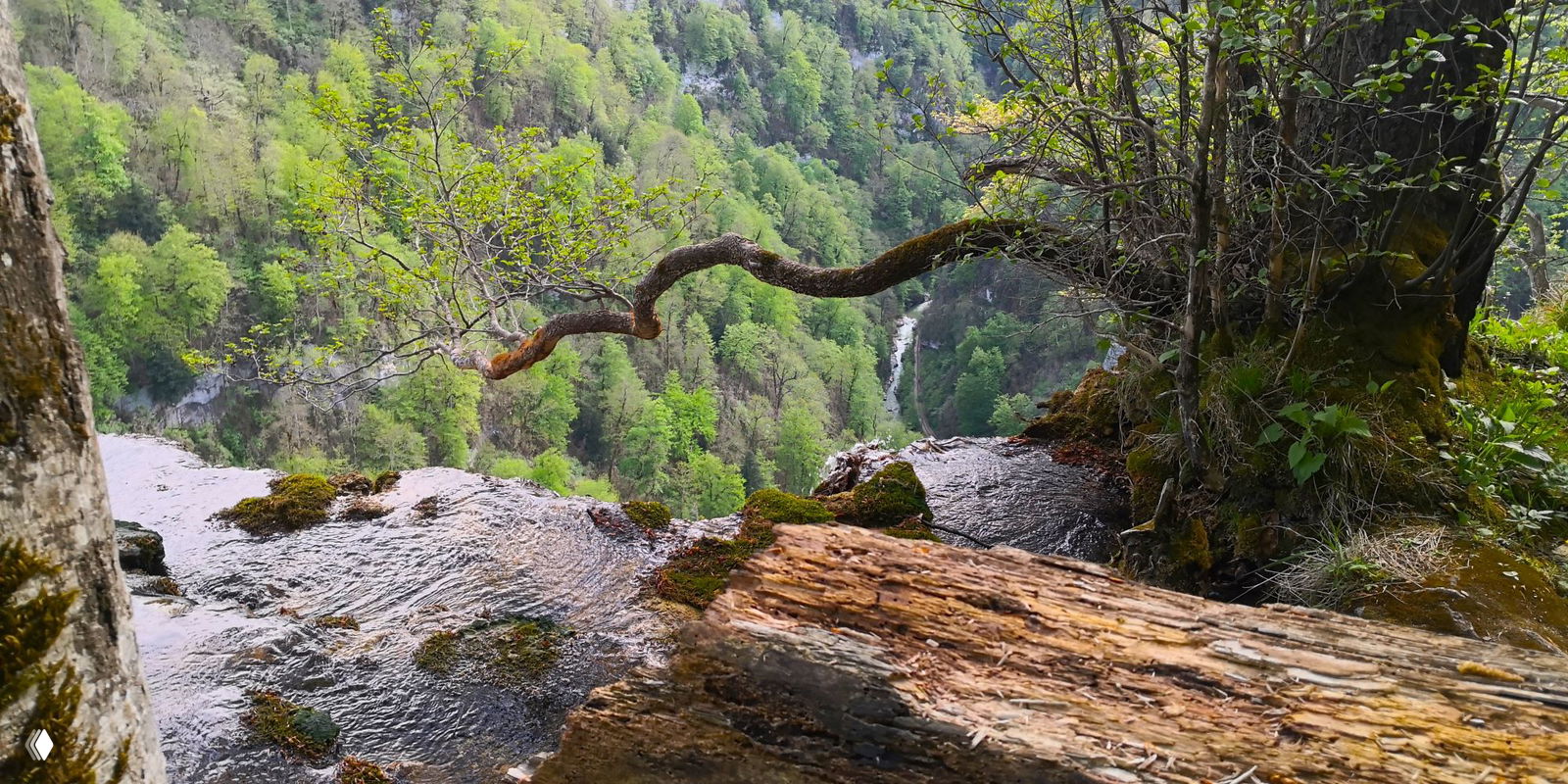 Спокойный участок реки у посёлка Мезмай с мелководьем и зелёной лужайкой на берегу, место для отдыха после похода по ущелью.