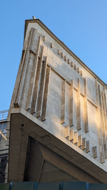 Монументальное фасадное здание в Ярославле с тяжёлыми вертикальными элементами; фотография архитектурного ракурса в дневном освещении.