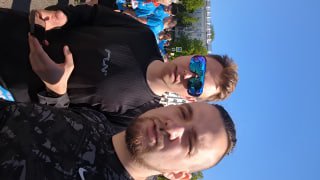 Селфи автора и товарища в спортивной одежде на фоне участников забега; улыбающиеся лица, солнце и общая радость от события.