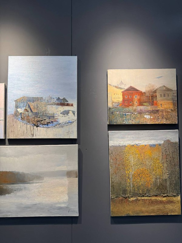 Несколько небольших абстрактно-ландшафтных картин на тёмной стене выставочного пространства, фокус на фактуре и цвете работ.