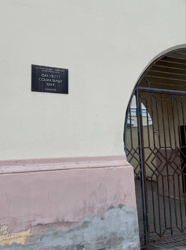 Фрагмент фасада и входная арка корпуса с табличкой: внешняя деталь здания института, где проходил психологический фестиваль и лекции.