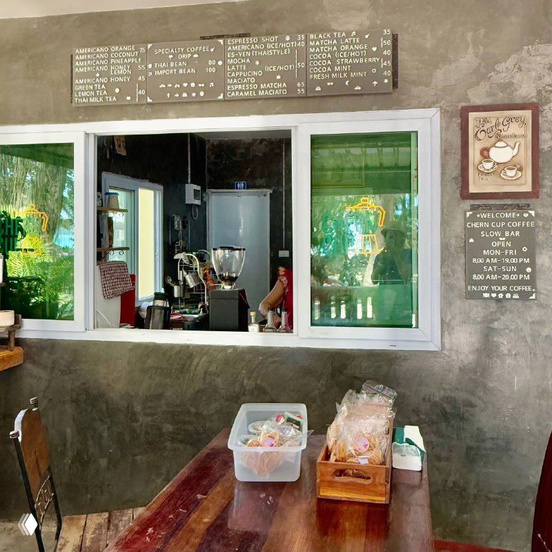 Окно-лужок кофейни с барной стойкой и меню на стене: интерьер простого местного кафе, рабочая зона бариста и рукодельная атмосфера.