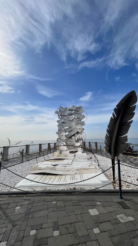 Крупный белый арт-объект на смотровой площадке острова — современные скульптуры на фоне моря и неба, площадка для фотографий.