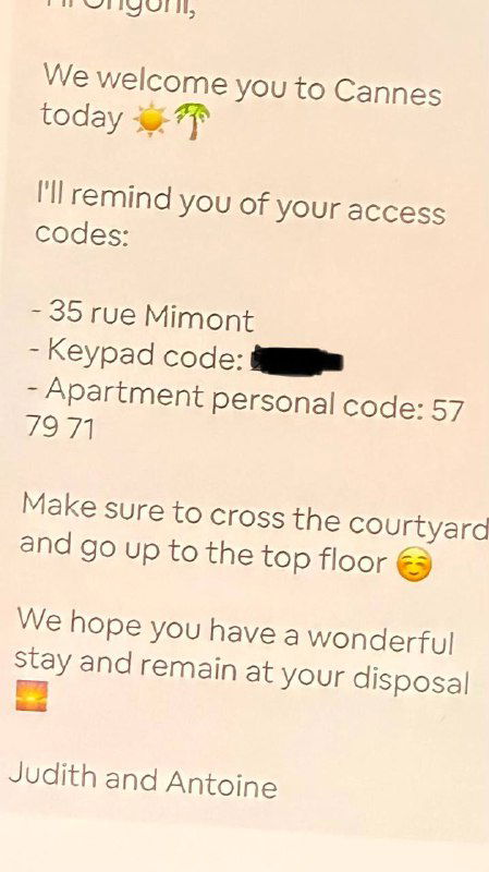 Листовка или записка с приветствием и напечатанными кодами доступа к апартаментам; часть цифр затемнена на фото для конфиденциальности.