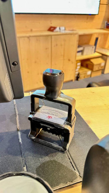 Металлическая печать сувенирного штампа на стойке туристического центра — механический штамп для отпечатка в паспорте или на открытке.