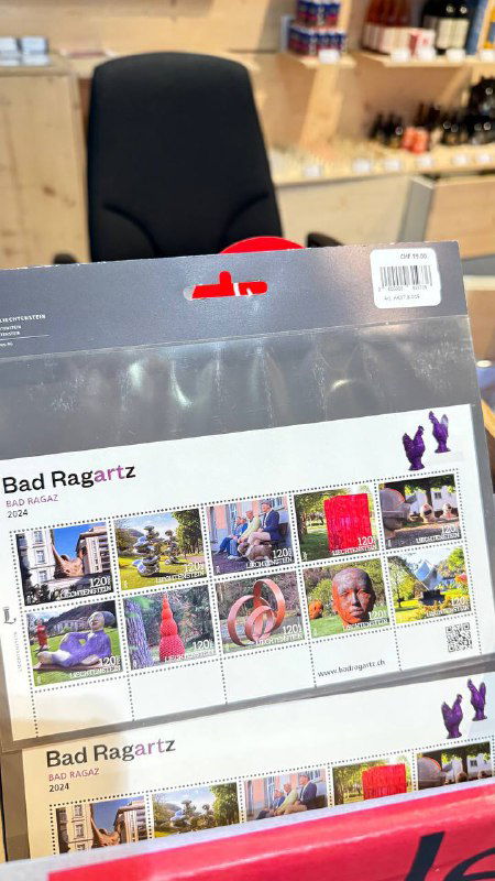 Разноцветный буклет с коллекционными марками Лихтенштейна на прилавке, демонстрирующий филателистические сувениры и дизайн марок.