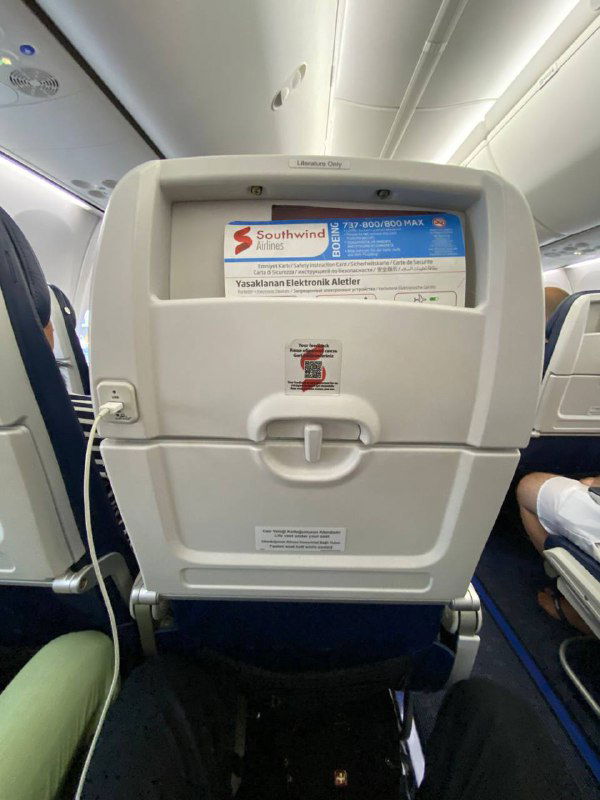 Вид на спинку кресла в салоне рейса Southwind: карман, отсек для меню, USB-порт и общий интерьер эконом-класса