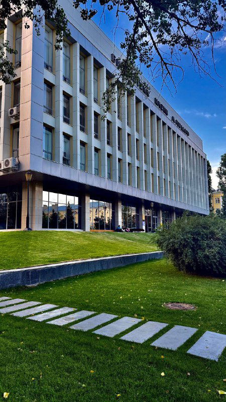 Фасад и лужайка перед зданием библиотеки в Волгограде: панорама с дорожкой и современным архитектурным обликом.