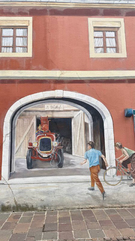 Настенная сцена с каретой и прохожими, оформленная как мурал — пример того, как граффити органично вписывается в историческую среду Мюлуза.