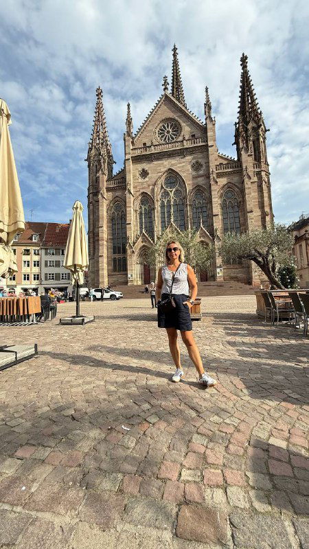 Центральная площадь у готического протестантского собора Мюлуза: мощёная площадь, высокая церковь и человек на переднем плане для масштаба.
