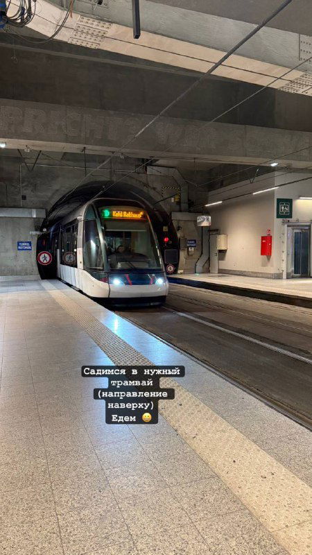 Современный состав страсбургского трамвая на подземной платформе — видна передняя часть поезда, рельсы и освещённая станция.