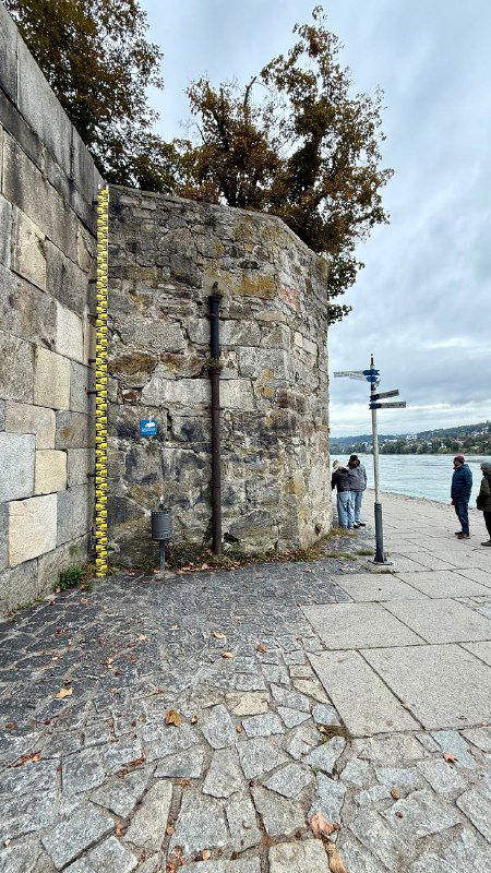 Гидромерная рейка у набережной Пассау: мерная шкала для уровня воды на каменной стене, отражающая историю наводнений в городе.