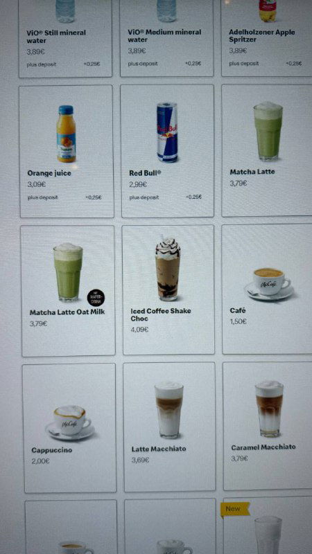 Фотография сетки меню напитков и десертов в немецком McDonald's: матча, Red Bull, кофе и другие позиции с ценами на экране