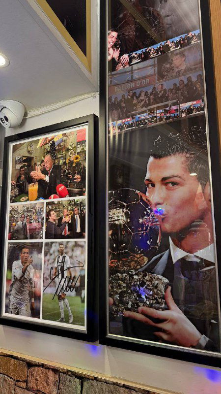 Фоторамки с изображениями Криштиану Роналду и футбольные коллажи висят на стене бара среди других памятных предметов.