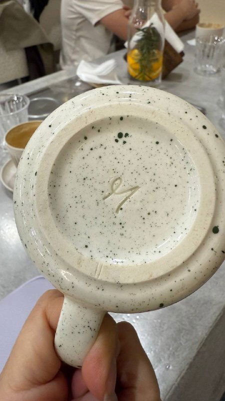 Дно керамической чашки с фирменной клеймой и фактурной глазурью — посуда от саратовского производителя, используемая в кофейне.