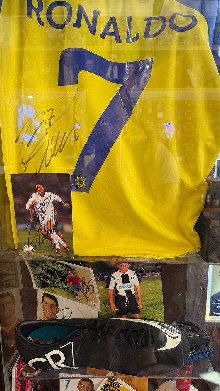 Автографированная футболка с номером 7 в витрине бара среди других футболок и памятных предметов CR7.