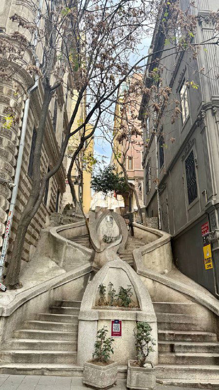 Знаменитая лестница Камондо между зданиями: каменные ступени, скульптурные украшения и узкая городская улочка в Стамбуле, популярная у фотографов.