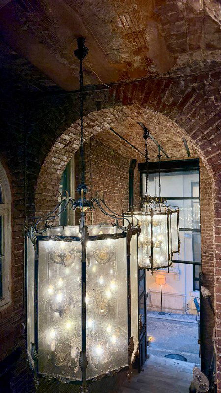 Подвальные помещения Rumeli Han: кирпичные своды, висящие светильники и тёплое рассеянное освещение, интерьер с промышленным шармом.