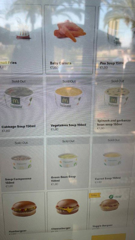 Фотография меню на экране с перечнем супов и блюд Макдональдса в Португалии, видны названия нескольких крем‑супов и иконки блюд.