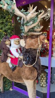 Инсталляция с фигурой оленя и маленькими персонажами, оформленная внутри киоска — тёплая рождественская сценка на улице Измира.