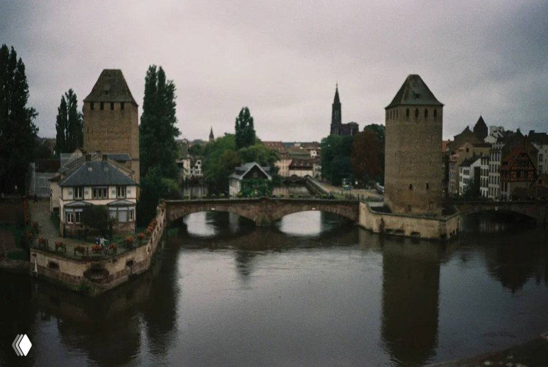 Вид на мост и башни Страсбурга с реки: исторические башни, мост и приглушённое освещение — характерный пейзаж эльзасского города.