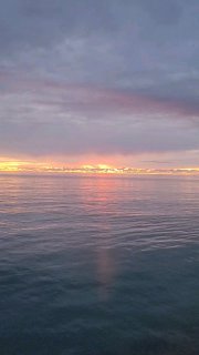 Спокойное море на рассвете/закате с приглушёнными пастельными оттенками неба и отражением света на воде — образ для успокоения и отдыха в тексте.