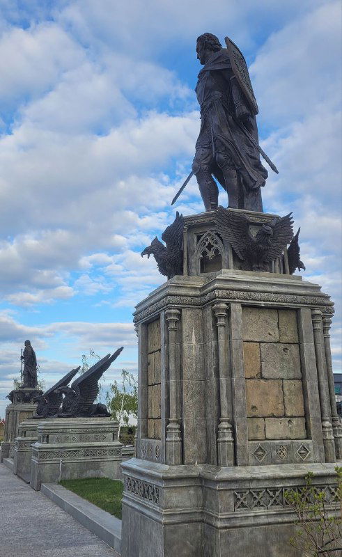 Статуя в образе воина с мечом на высоком каменном пьедестале, часть монументальной композиции у замка Гарибальди
