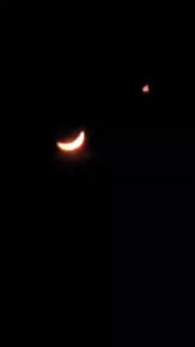 Фото ночного неба: тонкая серпообразная молодая Луна и яркая точка (Венера) выше справа на черном фоне — кадр с мобильного.